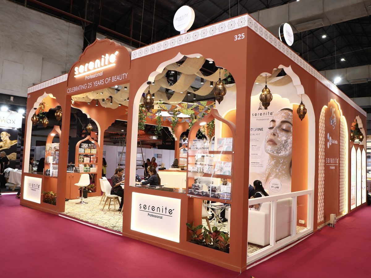 Side view of the Serenite Professional booth at Professional Beauty India Mumbai 2026, with product shelves and seating for salon conversations